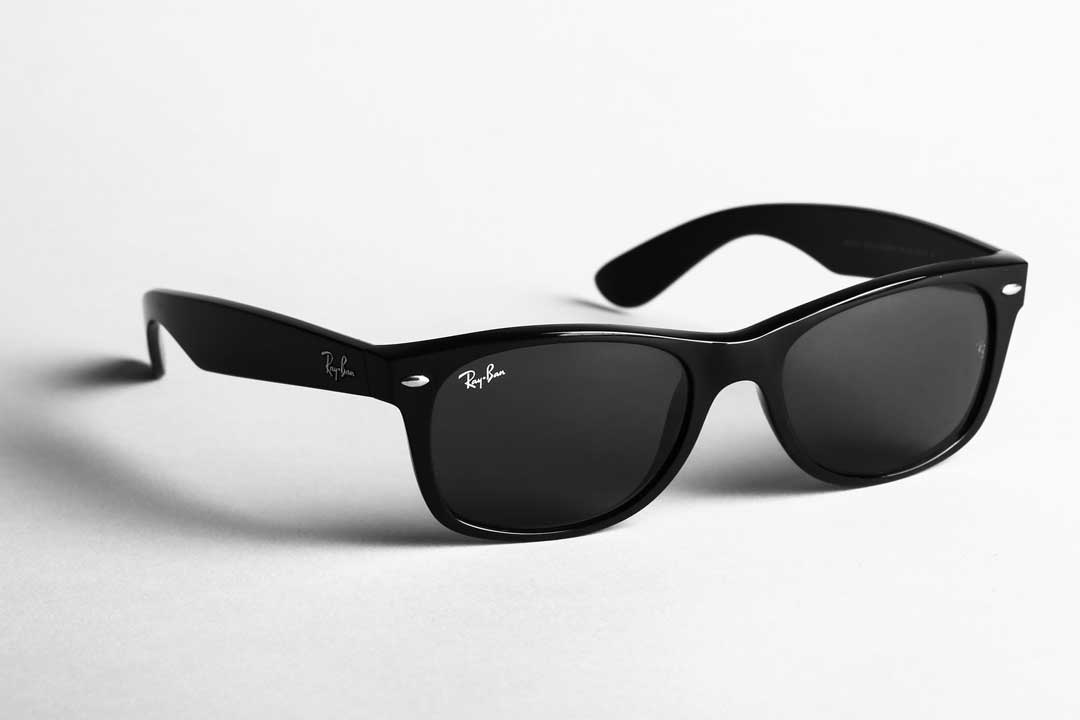 Three quarter view of black RayBan Wayfarer sunglasses frame on white background