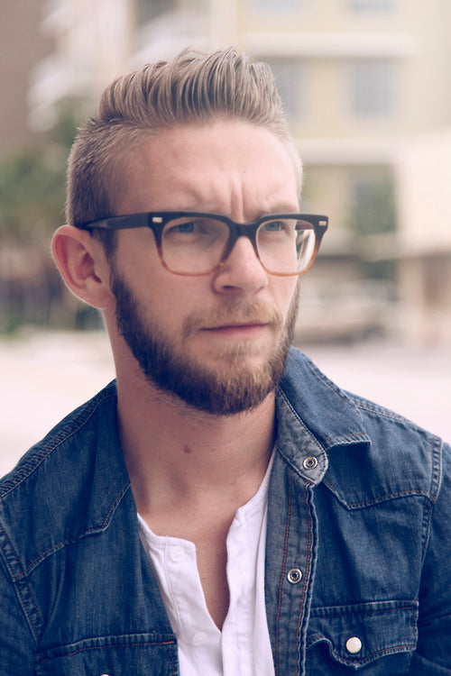 Three quarter view of blonde man wearing thick rimmed spectacles