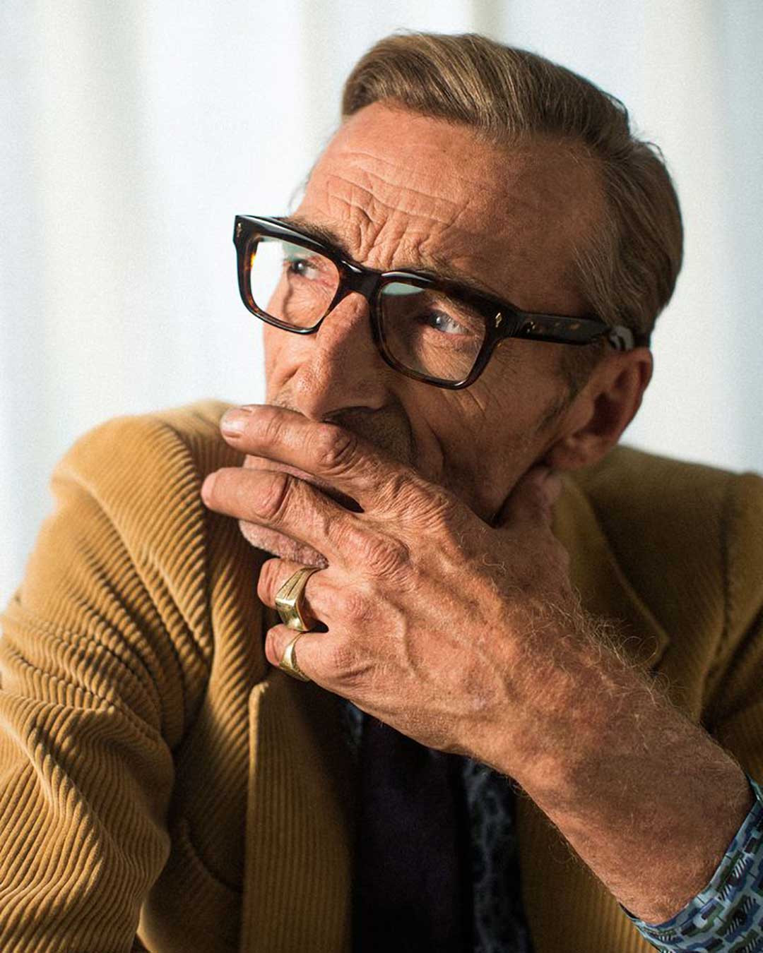 Three quarter view of mature man wearing mustard corduroy short and thick eyeglasses frame