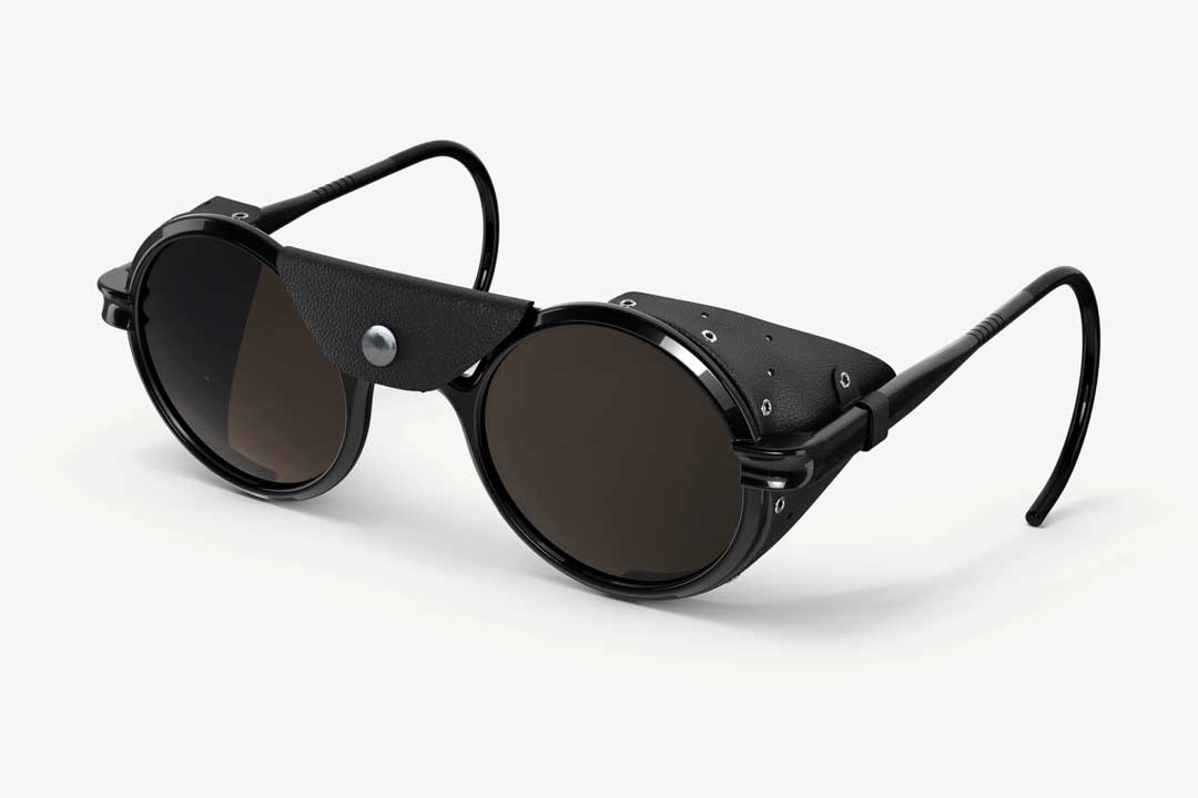Three quarter view of round glacier style sunglasses with leather side shields and bridge blocker