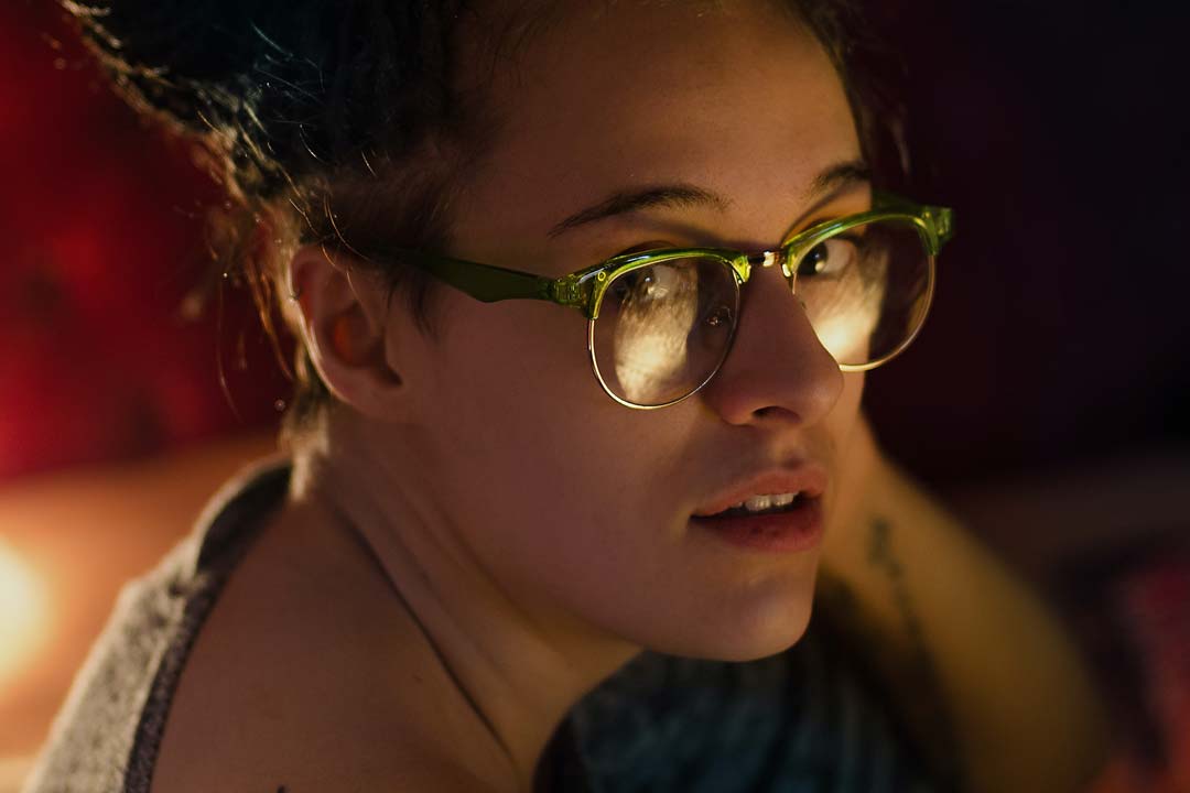 Three quarter view of woman wearing bright green browline eyeglasses