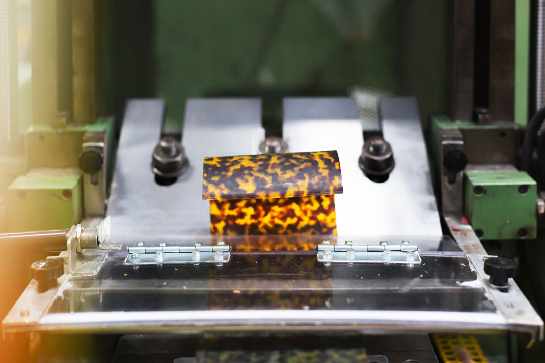 Tortoise cellulose acetate being sliced into sheets in factory