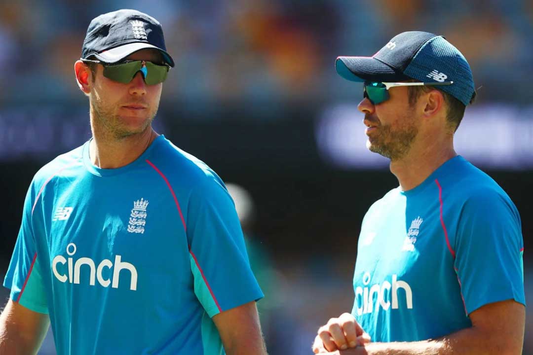 Two English cricket players on pitch wearing blue coloured strips and large sunglasses frames