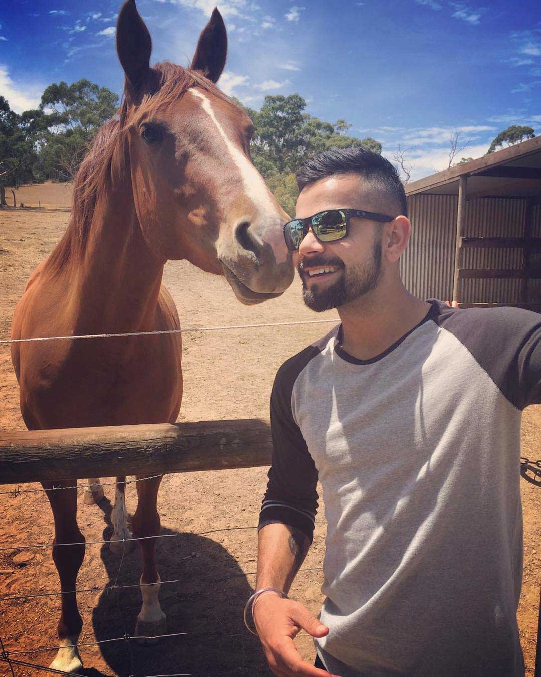 Virat Kohli wearing Oakley Holbrook sunglasses frame standing beside horse