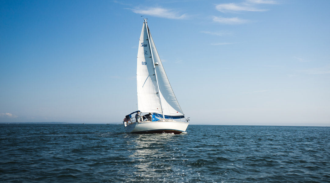 White yacht sailing on the sea on bright sunny day