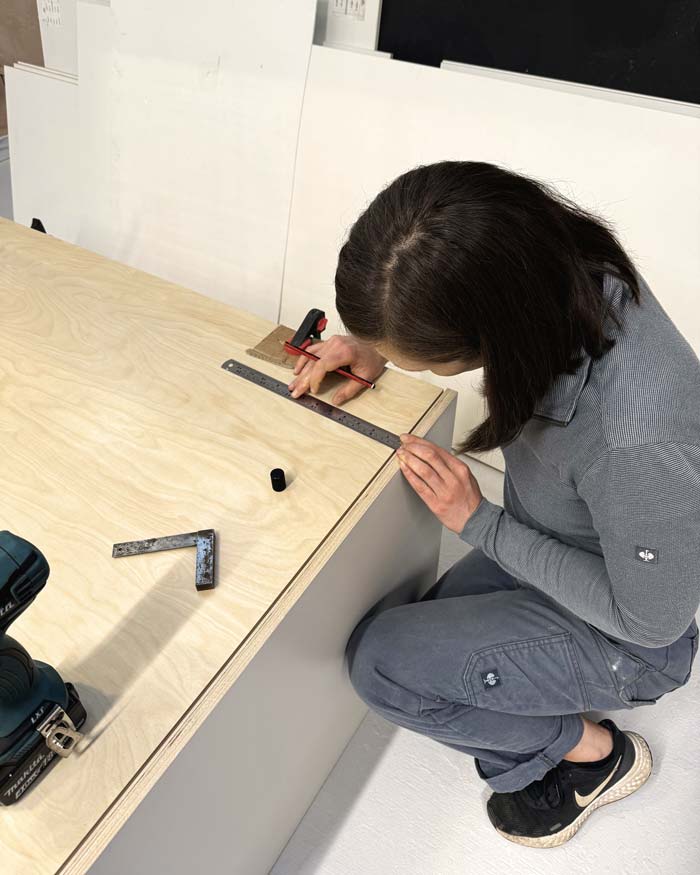 Woman marking holes to be drilled