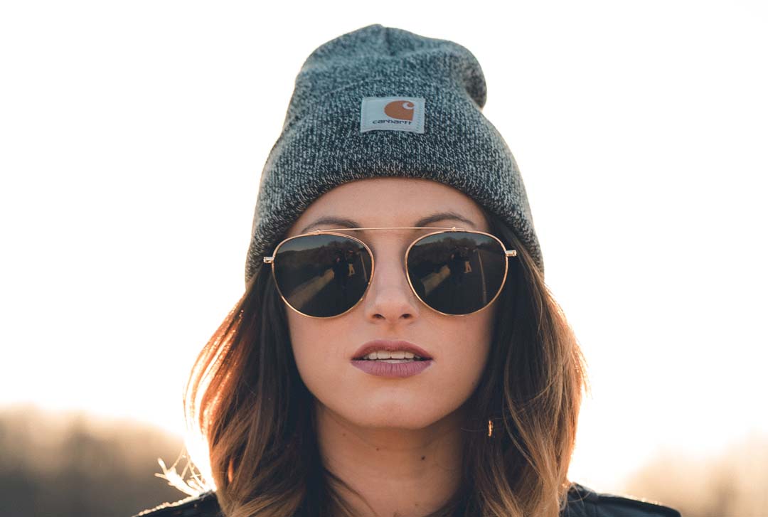 Woman wearing Aviator sunglasses grey wool hat and black jacket