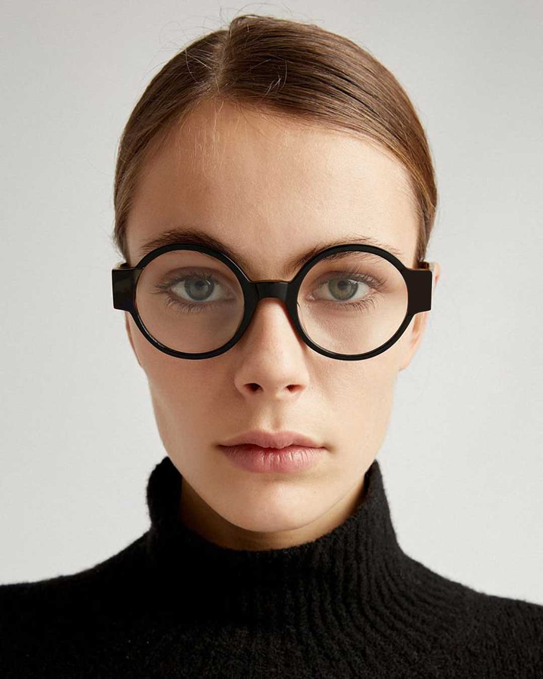 Woman wearing round black eyeglasses frame and turtleneck sweater