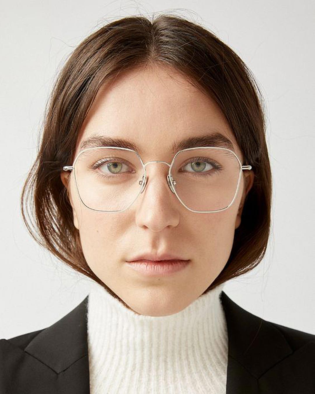 Woman with brown hair and square face wearing square wire frame eyeglasses looking straight on