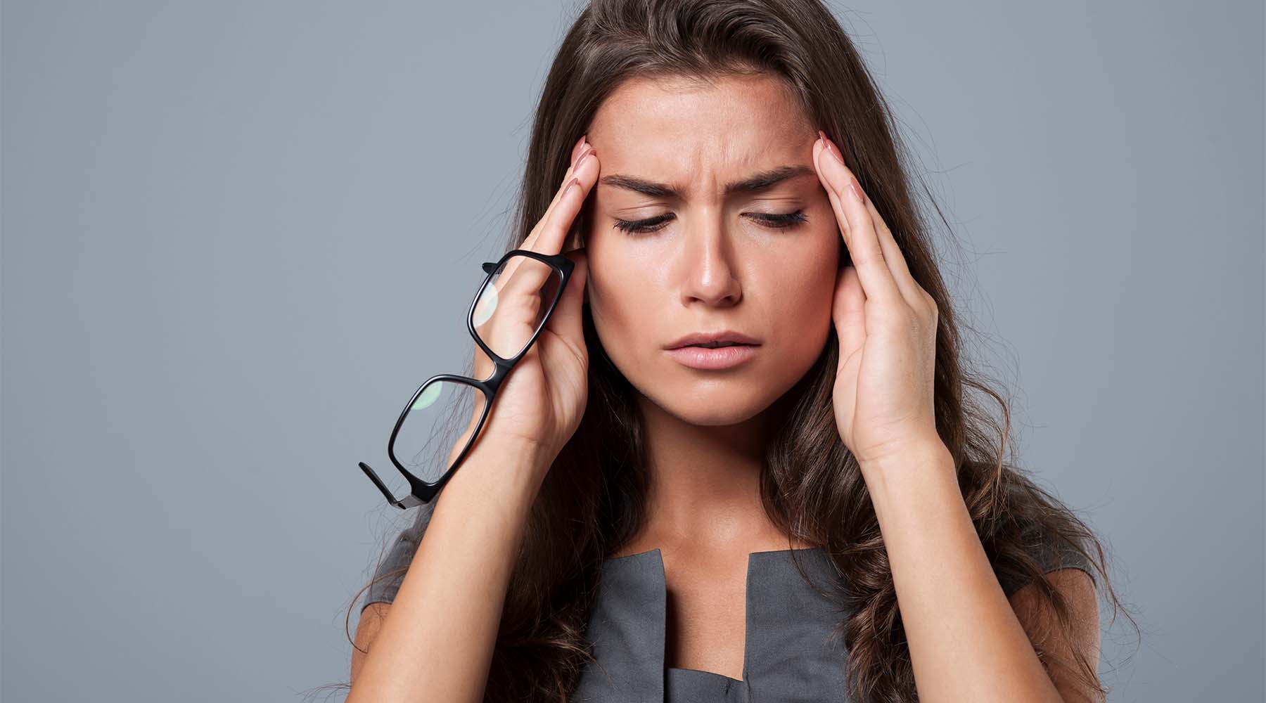 Woman with headache caused by her glasses