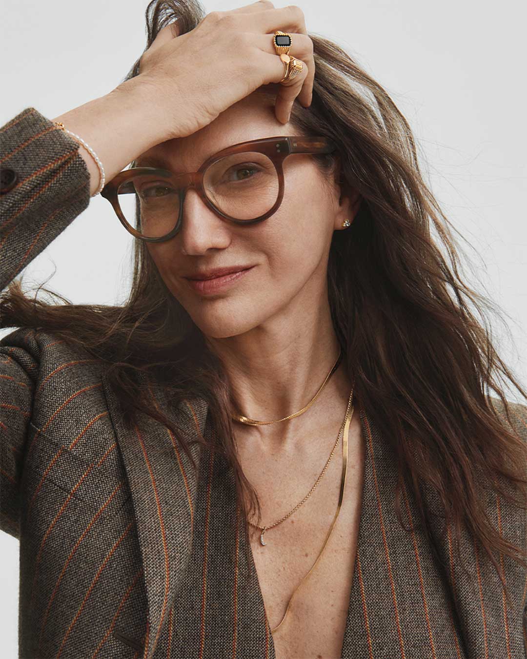 Woman with long brown hair wearing thick oversized brown eyeglasses frame