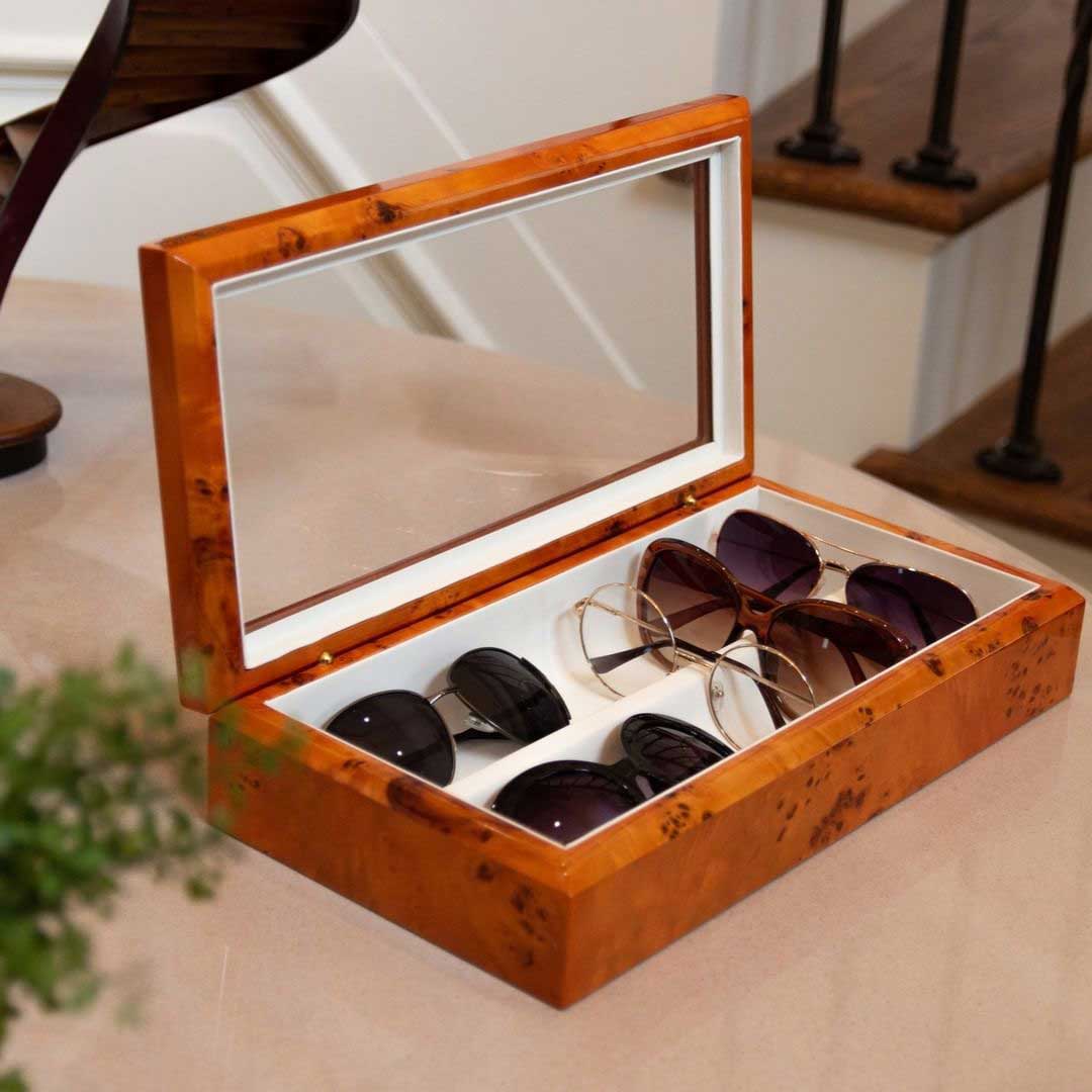 Wood sunglasses box with glass lid lying on beige table top