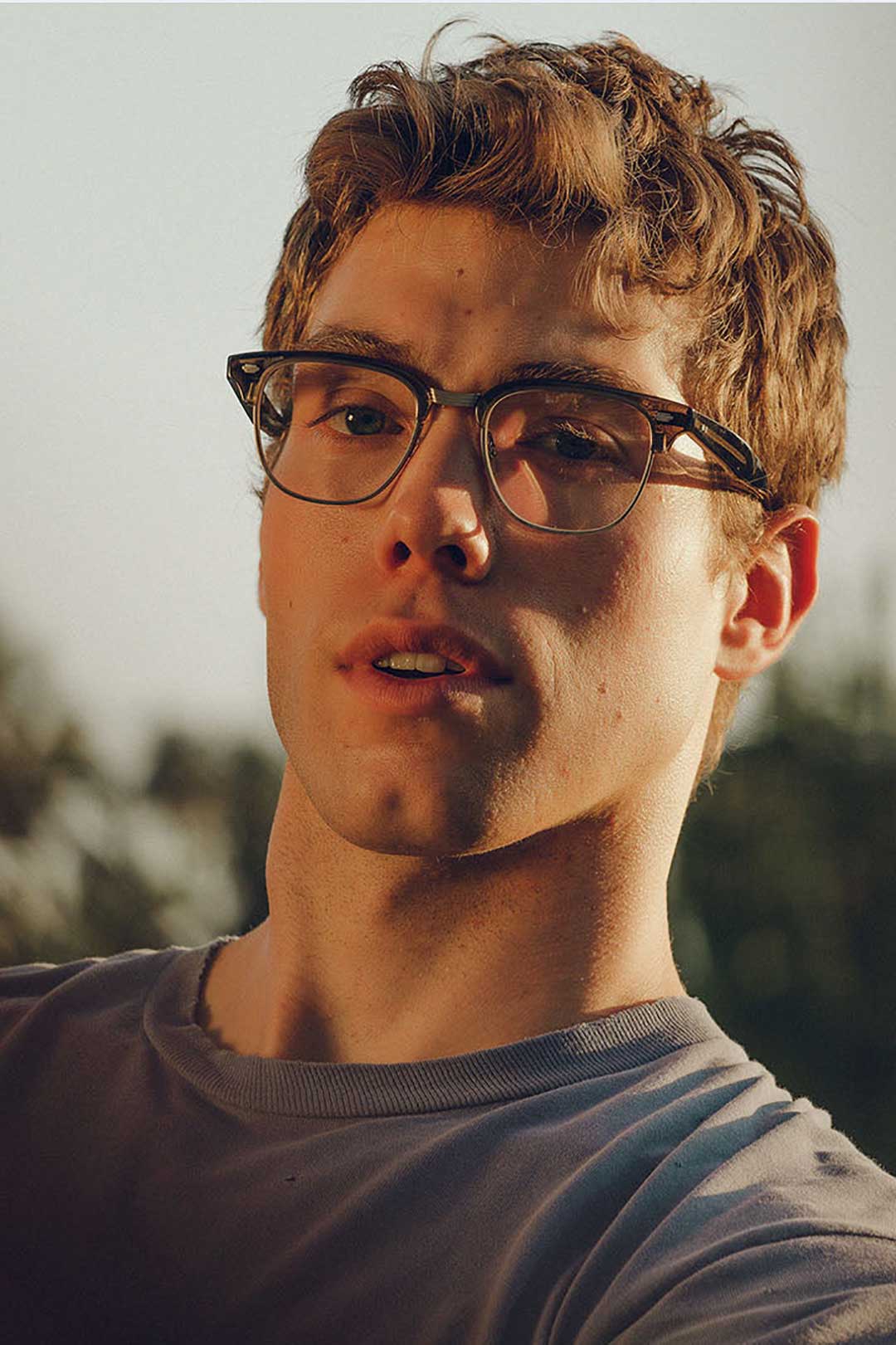 Young male wearing Garrett Leight Elkgrove semi rimless glasses frame