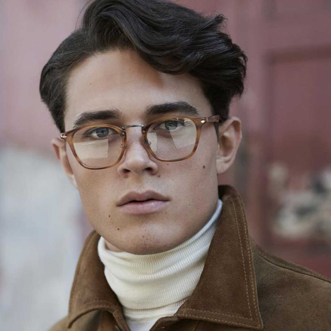 Young man wearing brown coat and amber coloured spectacles