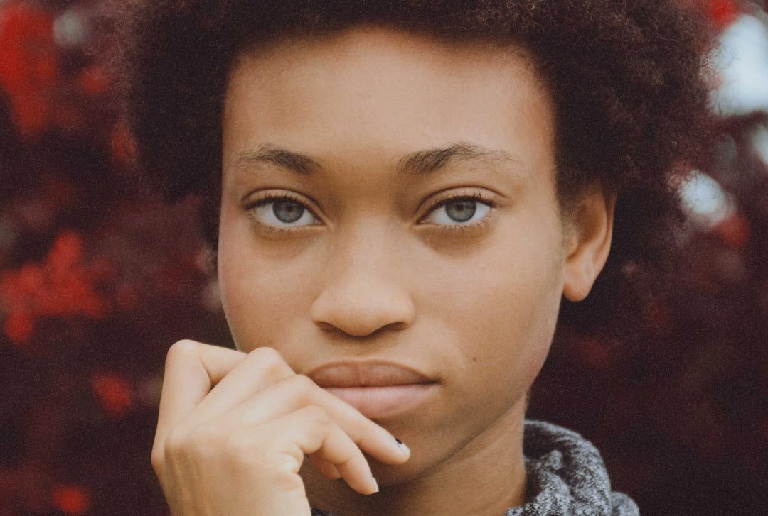 Young women with big hair and square face looking straight at viewer