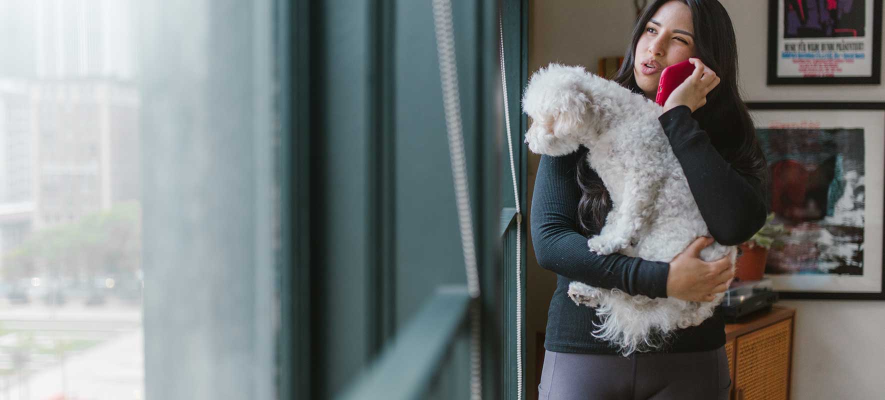 Lady holding dog while on phone