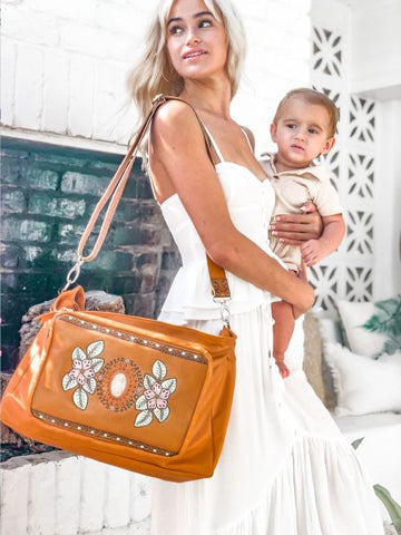 mother and baby with leather baby bag