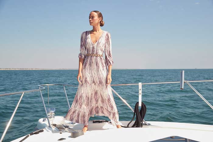 woman wearing long dress with ruffled trims on a boat