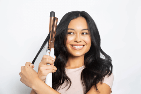 Woman holding curling iron through hair