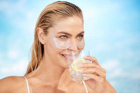 woman drinking water wearing eye patches