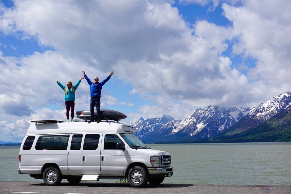 Jake and Emily Standing on top of their van 