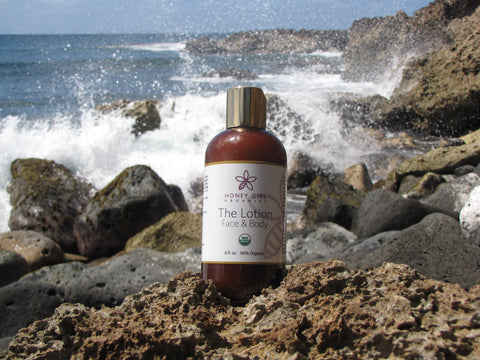 Honey Girl Organics Lotion in front of waves