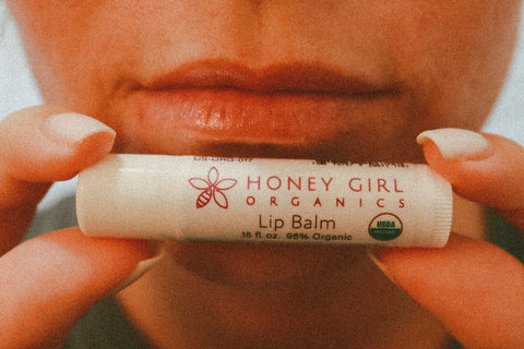 Holding the HGO Lip Balm in front of lips