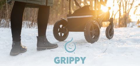 Parent walking with their stroller on snow with the sun in the background and grippy covers helping them navigate.