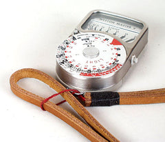 Attaching strap to light meter. Leather neck strap. Light brown leather black wrap. 