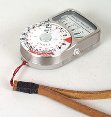 Attached strap to light meter. Leather neck strap. Light brown leather black wrap.