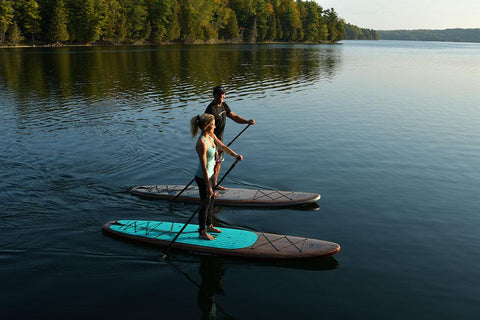 A couple paddle boarding on a lake
