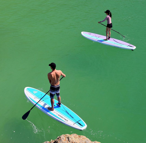 Male and female stand up paddle boarders
