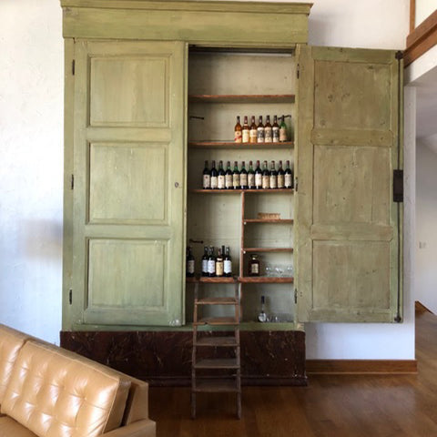 Tuscan Style Home Décor: A Guide The 5 Main Things to Know - A very large 18th century cabinet from MERCATO Antiques bolding defines this space in this room with high ceilings.