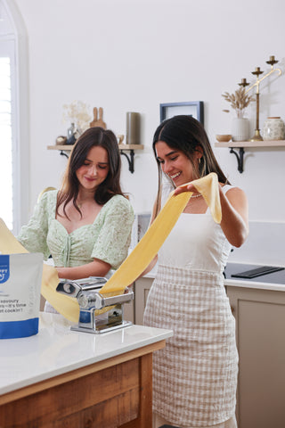 Girls making pasta with Flavourless Protein Powder