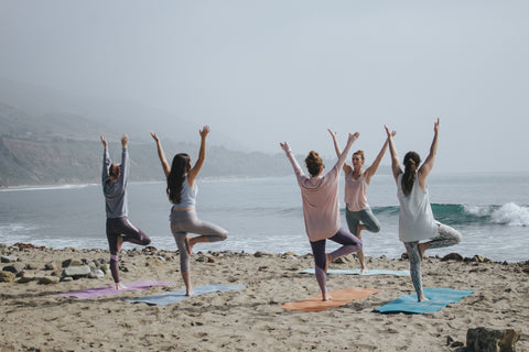 Women doing yoga on the beach