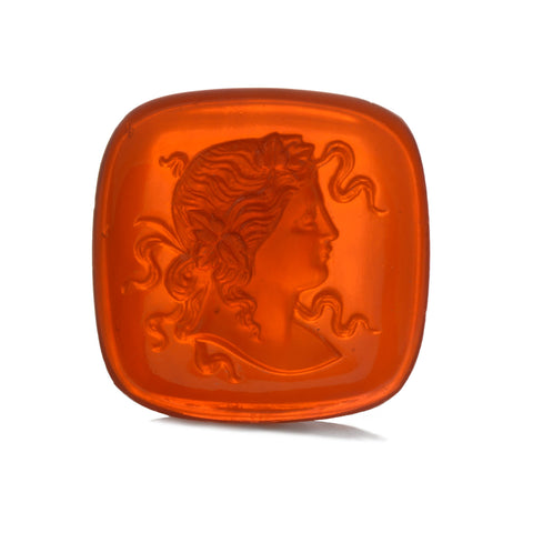 An orange sardonyx gemstone that has been carved with a profile of a goddess with snakes for hair.