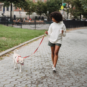 woman walking dog through the park
