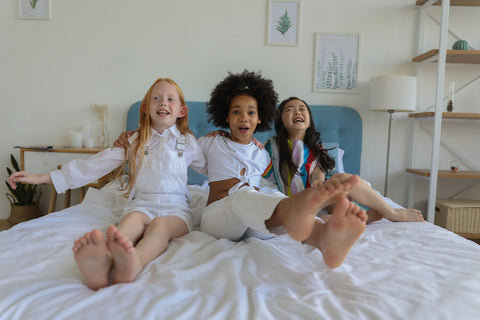 young girls laughing on a bed