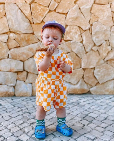 baby eating ice cream in dungarees and hat