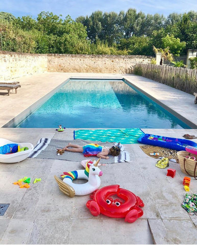 Pool with child lying by the side of it