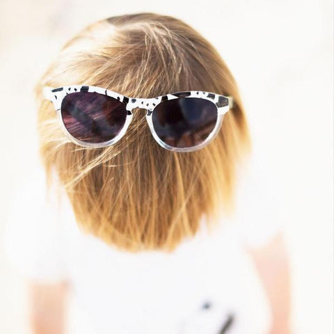 Lifestyle picture of panda printed sunglasses worn on top of child's head as featured on little hotdog watson blog