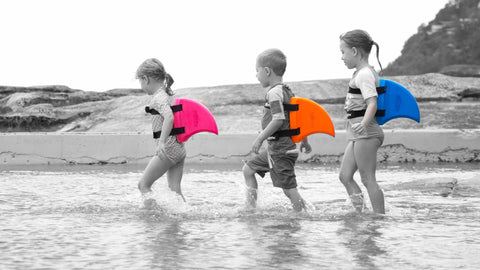 Kids Wearing Swimfin Swimming Aid In Pink Orange and Blue