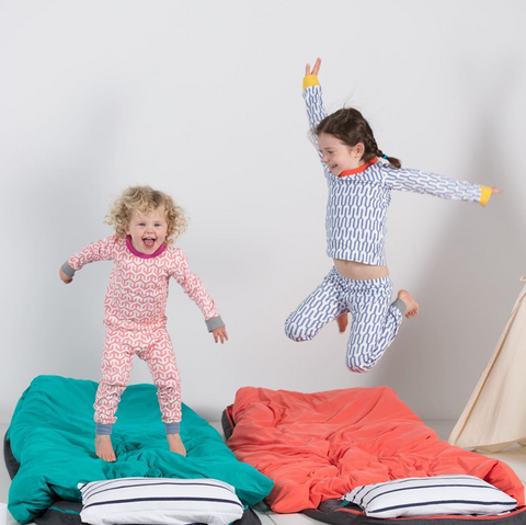 Two kids jumping up and down on Bundle Beds camping beds