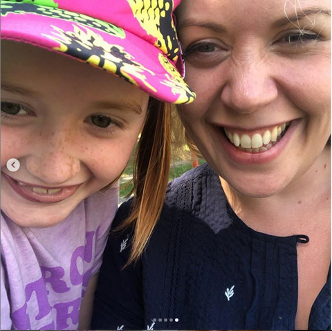 Mum and daughter smiling daughter wearing pink pineapple sun hat