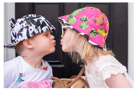 Boy and girl kissing wearing little hotdog watson sun hats