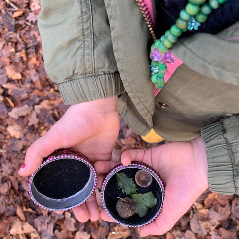 Child Collecting Nature Items in Jar