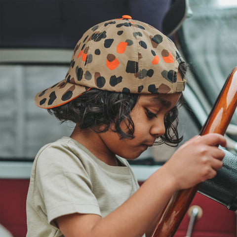 Child wearing Little Hotdog Watson leopard print baseball cap back to front in a car