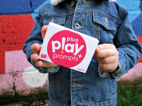 play prompt cards being held by child in denim jacket