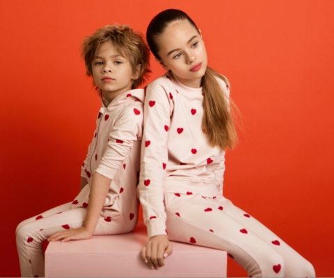Children wearing pink lounge sweater with red hearts