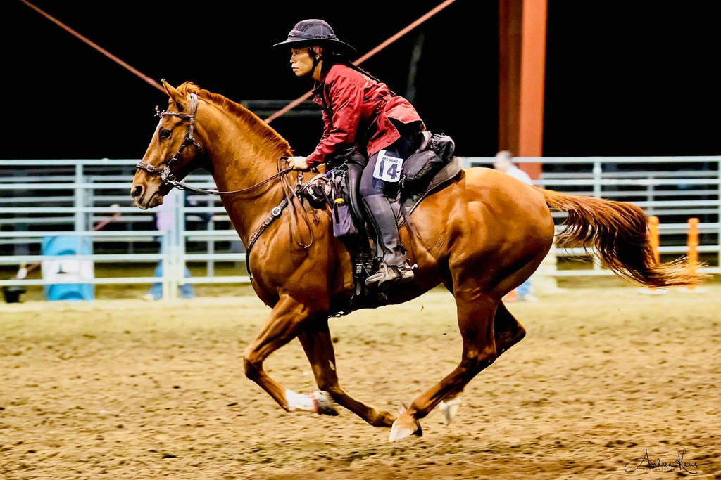Dawn Champion riding her brown barefoot horse in a barrel racing competition 